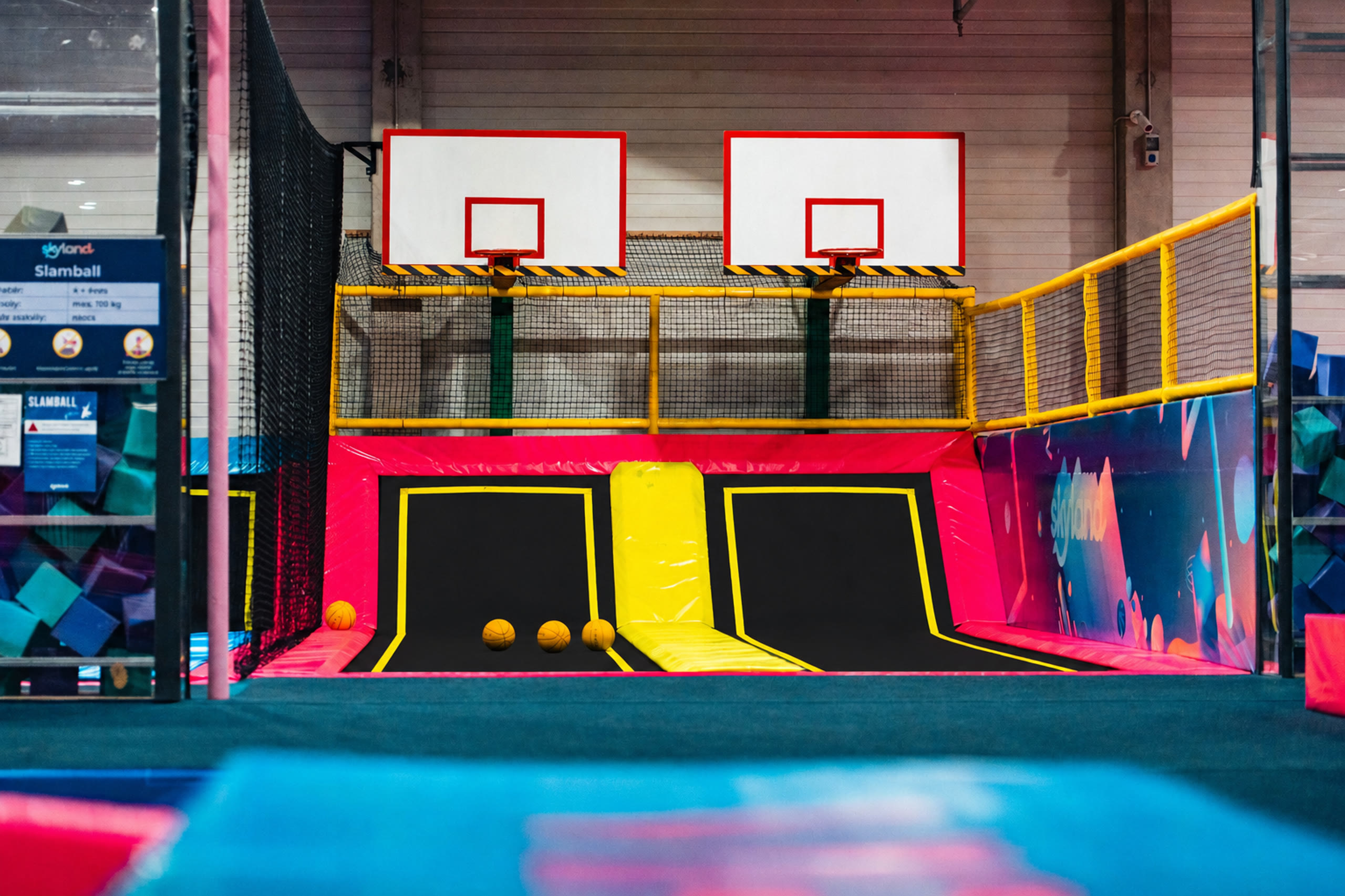 Két kosárpalánk trambulinos nekifutó sávokkal a Skyland Park Slamball zónájában